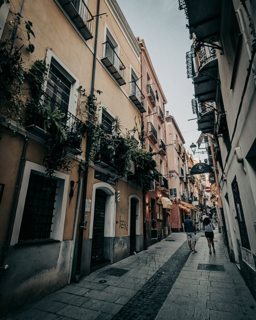 Cozy narrow street in Europe with colorful buildings and pedestrians.