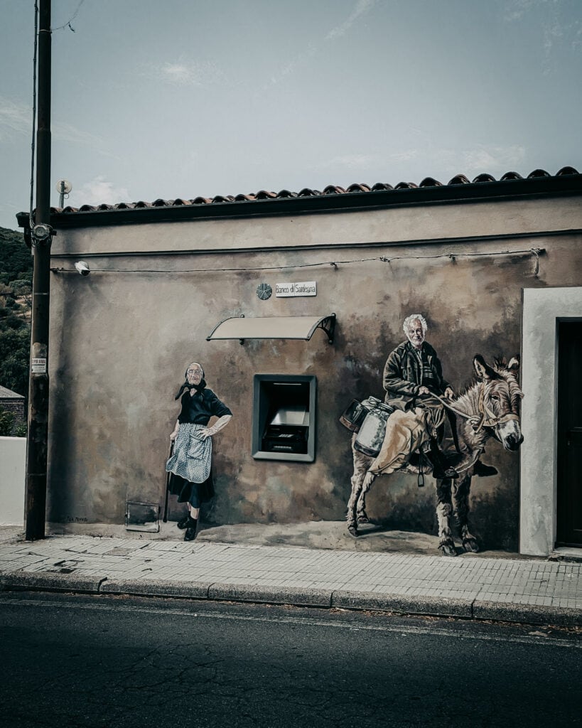 Colorful street art mural depicting a woman and a man on a horse on an urban wall.